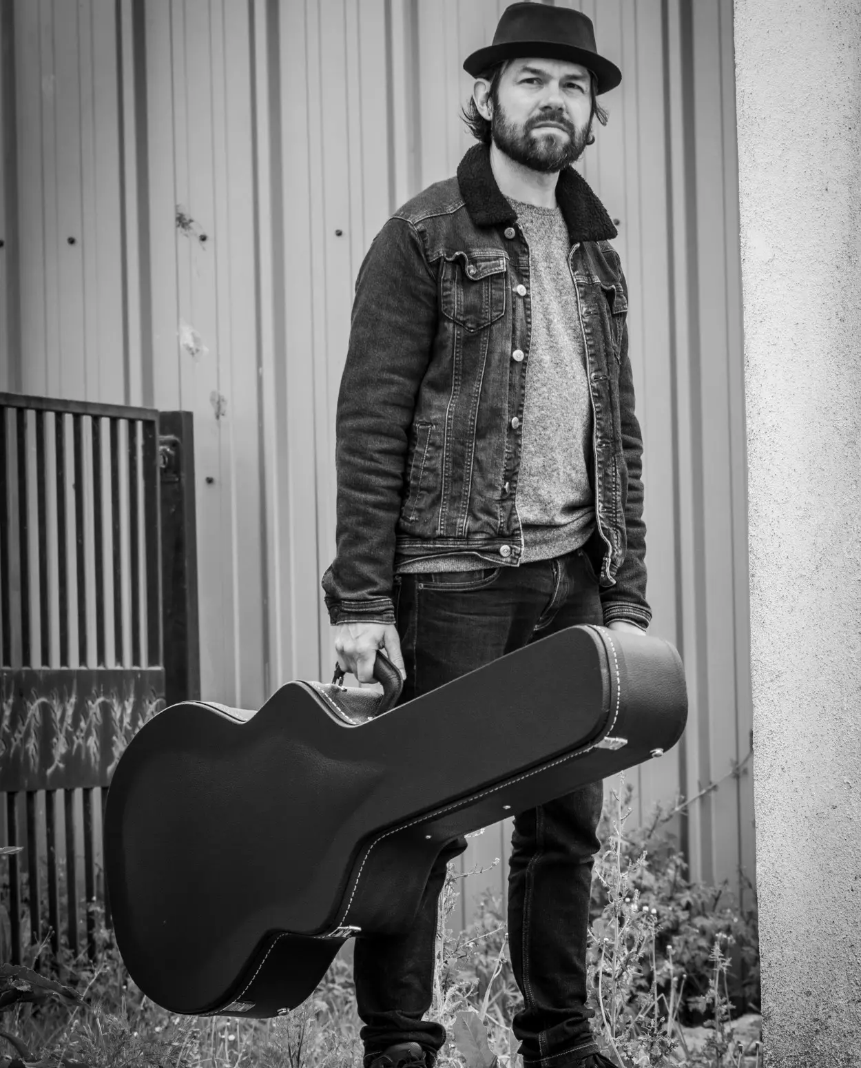 man with guitar case