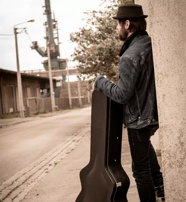 man with guitar case