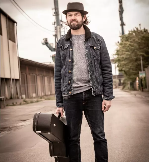 man with guitar case